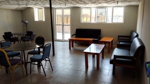 Una habitación con una mesa de comedor, sillas, un sofá y un ventilador.