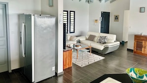 A modern living room with a sofa, a coffee table, and a refrigerator. - Villa Vaïtea, pool, sea view, 3 bedrooms, Leroux area (Deshaies)