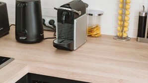 Eine Küche mit integriertem Weinkühler, einer Kaffeemaschine und einem Besteckhalter.