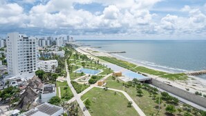 Un paisaje urbano costero con rascacielos, una playa y cielo despejado.