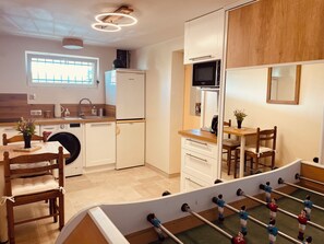 Enjoy meals in the well-equipped kitchen with appliances and dining area, perfect for a home-cooked meal or game night.