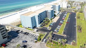 A hotel with a parking lot, beach access, and ocean views.