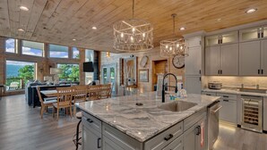 A spacious kitchen with granite countertops, stainless steel appliances, and wooden ceiling beams.