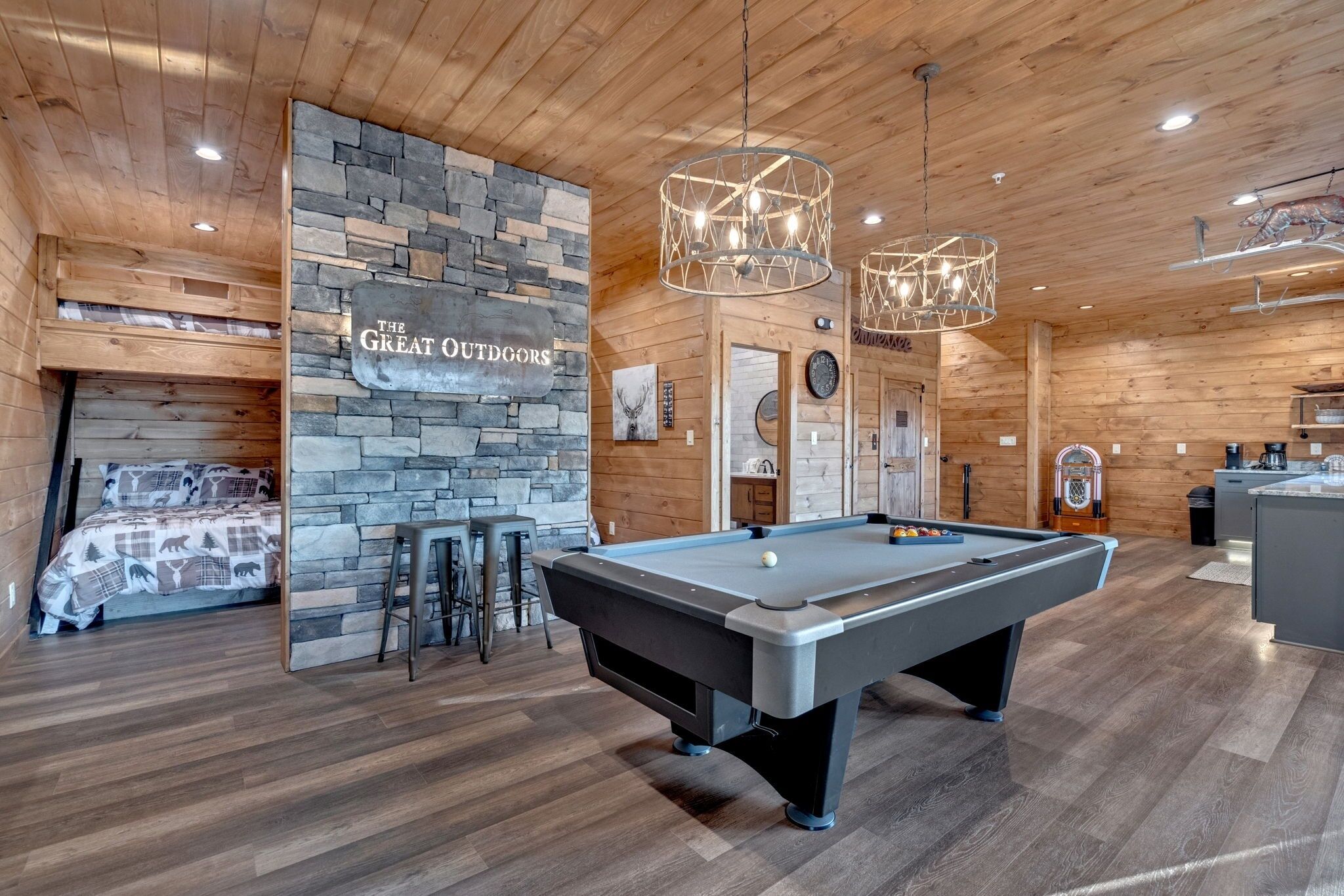 Ein Billardtisch in einem Holzraum mit einer Steinwand und einem Schild mit der Aufschrift 'The Great Outdoors'.
