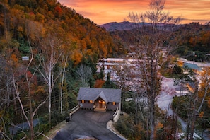 A lodge with a stone facade, a central entrance, and a driveway leading to the parking area. - 4/4 Cabin w 4 King Suites|Hot Tub|Views 5 min to Gatlinburg! (Gatlinburg)