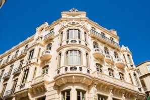 Ein historisches Gebäude mit aufwendigen architektonischen Details, darunter mehrere Balkone und große Fenster.