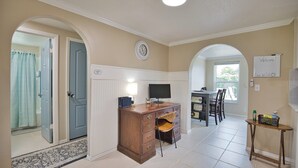 A well-lit room with a desk, chair, and a dining area with chairs and a table. - Welcome to Casa del Sol! Charming 2 bedroom home located 4 miles from the beach! (Englewood)