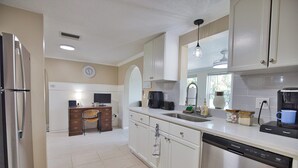 A kitchen with white cabinets, a stainless steel refrigerator, a dishwasher, and a coffee maker. - Welcome to Casa del Sol! Charming 2 bedroom home located 4 miles from the beach! (Englewood)