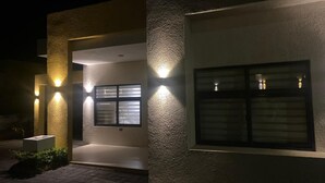 A modern building with textured walls and illuminated windows. - Amore Villa Retreat in Ocho Rios (Ocho Rios)