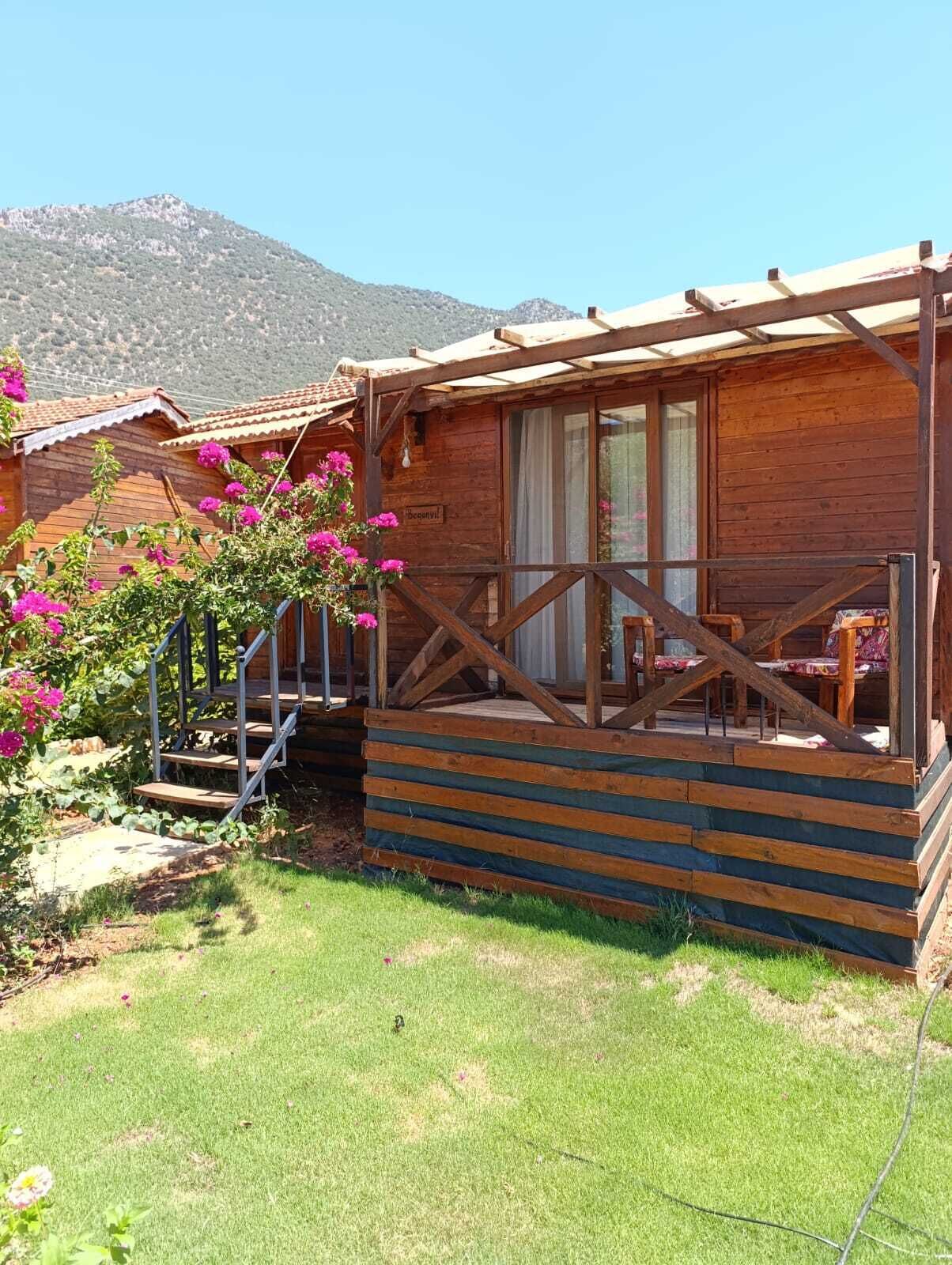 A wooden cabin with a porch and a staircase leading to the entrance.