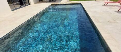 Una piscina al aire libre, una piscina climatizada