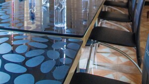 Une salle de conférence équipée d’une table en verre, de chaises et de bouteilles d’eau.