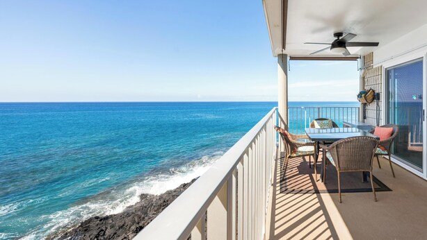 A balcony with a table and chairs overlooking the ocean. - Oceanfront Kona Condo | Watch Whales & Sunsets from Your Private Lanai (Kailua-Kona)