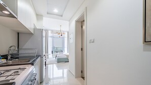 Una cocina moderna con extractor de acero inoxidable, pileta integrada y comedor con mesa y sillas.