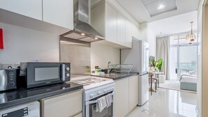 Una cocina moderna con electrodomésticos de acero inoxidable, una estufa a gas y un microondas.