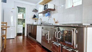 Een moderne keuken met roestvrijstalen apparatuur, witte keukenkastjes en een betegelde spatwand.