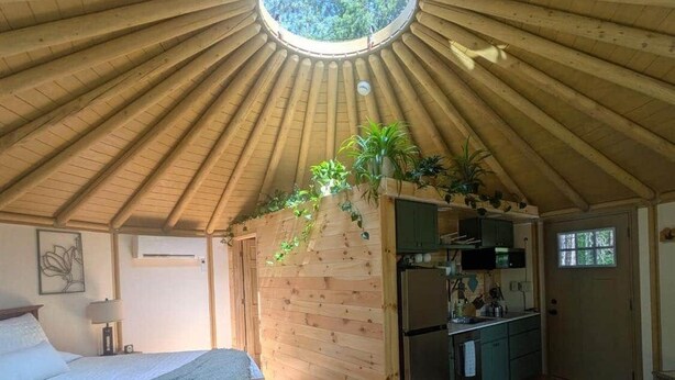 A cozy room with a wooden ceiling, a bed, a small kitchenette, and a seating area. - Romantic Hot Tub Get-a-way! (Coleraine)