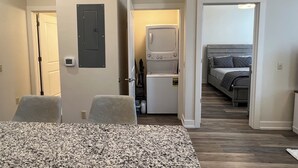 A compact hotel room with a kitchenette, a bed, and a dining area. - Downtown Adrian apartment with parking and wifi (Adrian)