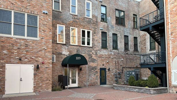 A brick building with a green awning marked "109" and a white door labeled "RESIDENTS ONLY". - Downtown Adrian apartment with parking and wifi (Adrian)