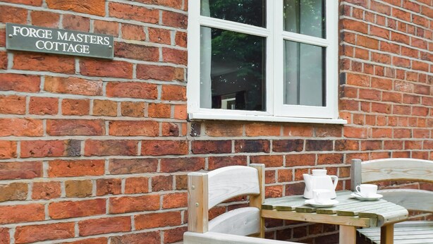 A brick wall with a sign reading "Forge Masters Cottage." - Forge Masters Cottage (Middlewich)