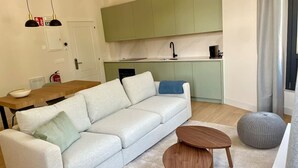 A modern living room with a light-colored sofa, a wooden coffee table, and a grey ottoman. - Sueño Indiano, Bajo Norte (Muros de Nalón)