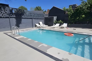 A swimming pool with a ladder, white lounge chairs, and a lifebuoy. -  Oceana Suites Briones Luco (Santiago)
