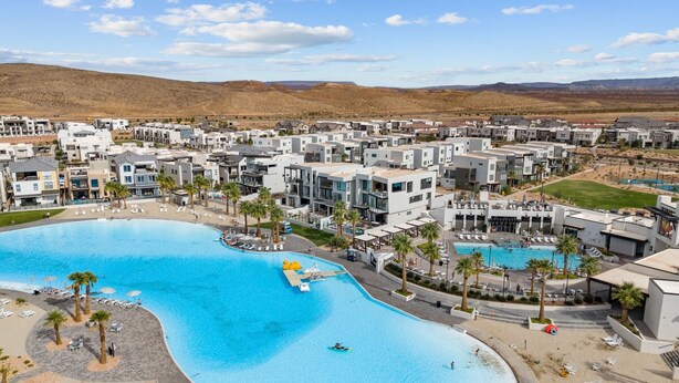 Un complex turístic amb una gran piscina central, diverses zones de bany i un paisatge desert al fons.