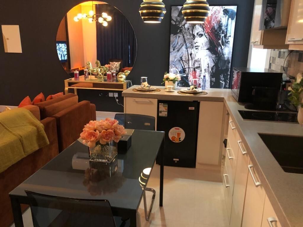A modern kitchen with a central island, a dining area with a table and chairs, and a living area with a sofa.