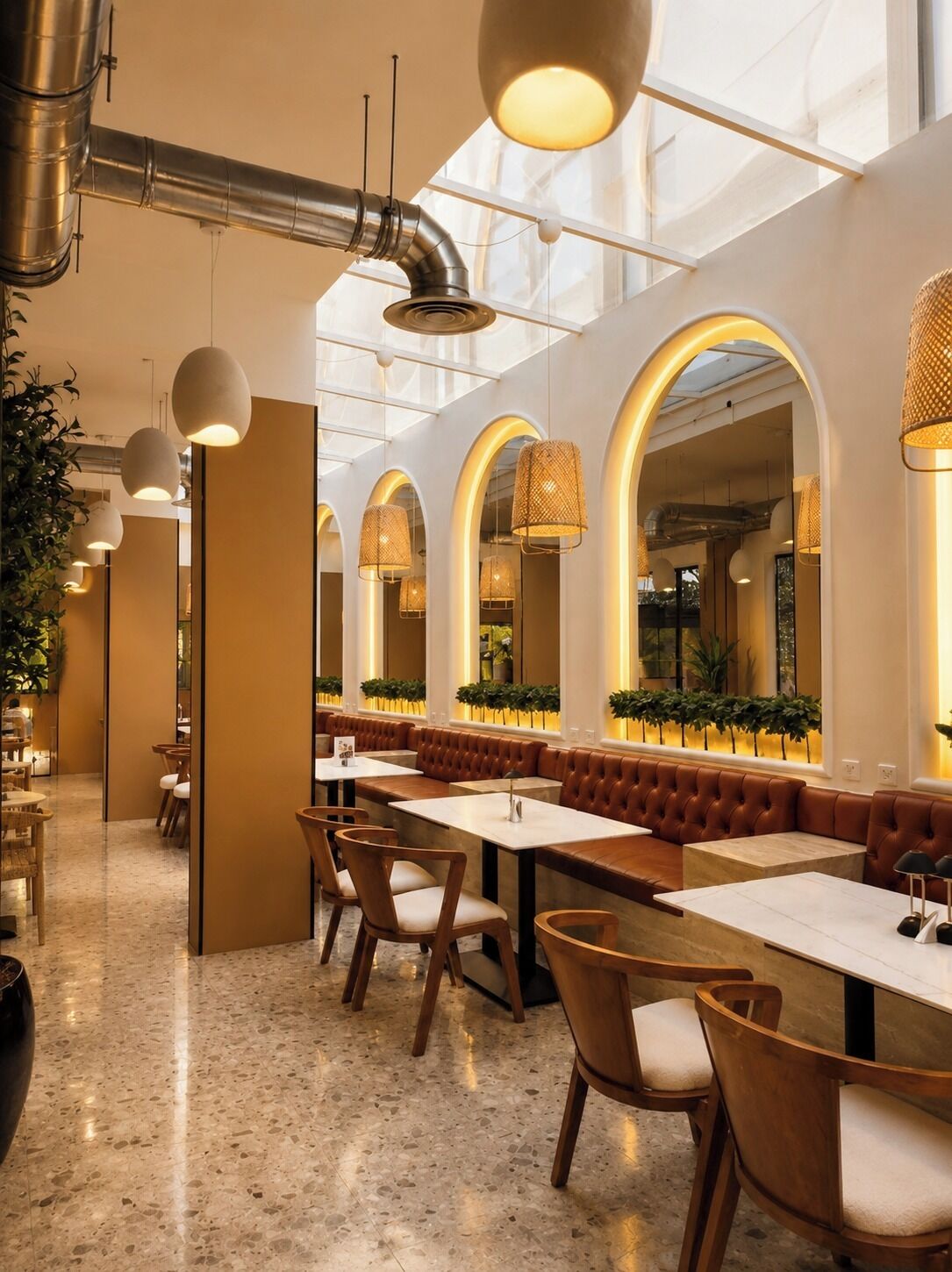 A modern restaurant interior with high ceilings, arched windows, and pendant lighting.