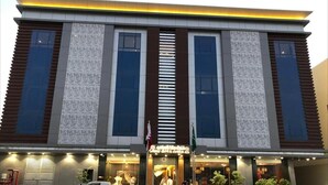 A modern building with a central entrance, large windows, and a flag. - Dana Serviced Apartments2 (Riyadh)