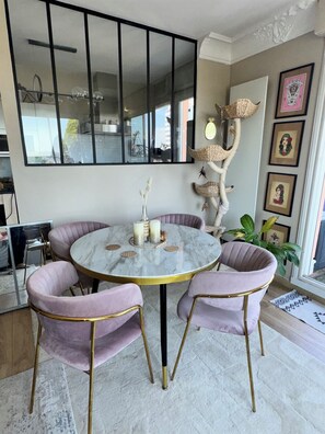 Enjoy meals in this stylish dining area with a round table, comfortable chairs, and a beautiful mirror.