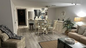 Un salon comprenant un canapé, une table basse et un coin repas avec une table et des chaises.