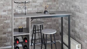 A bar area with a brick wall backdrop, a metal bar counter, two stools, and a wine rack with bottles. - 3 bedroom accommodation in Moota, Near Cockermouth (Moota, Near Cockermouth)