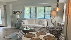 A dining area with a round table, wicker chairs, and a ceiling fan. - Pickleball/Tennis, Pool, Cozy Villa, Fast WIFI, 5 Minute Walk to the Beach (Hilton Head Island)