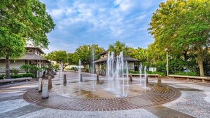 A courtyard with a central fountain, surrounded by trees and pathways. - Pickleball/Tennis, Pool, Cozy Villa, Fast WIFI, 5 Minute Walk to the Beach (Hilton Head Island)