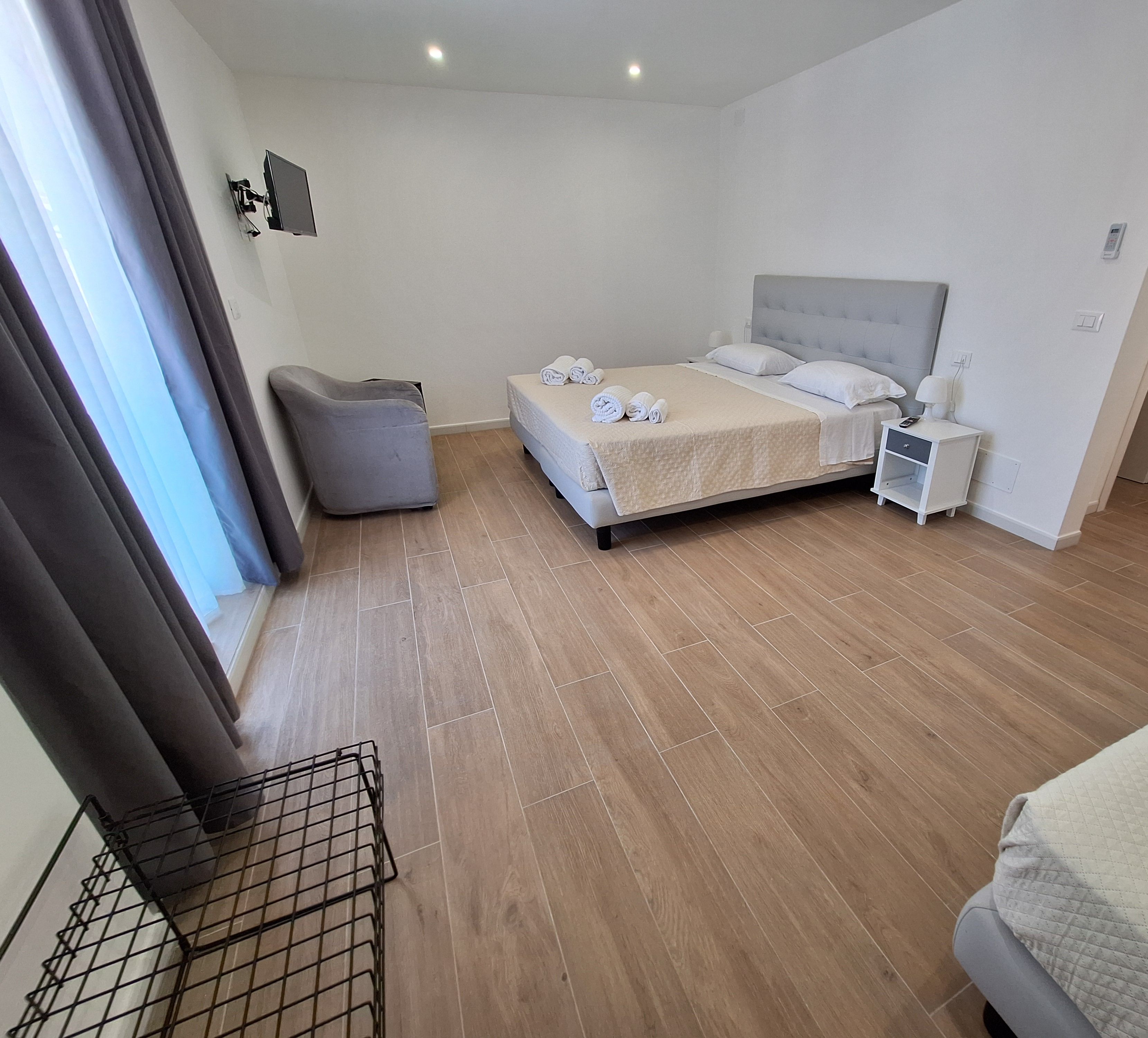A bedroom with a bed, bedside tables, a chair, and a window with curtains.