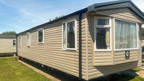 En mobilhome med et enkelt vindue og en dør, kendetegnet ved et simpelt og praktisk design.