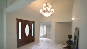 A spacious entryway with a large wooden door, a chandelier, and a potted plant. - THE BIG HOUSE ~ With 620 sq ft EVENT SPACE ~ (view on YouTube "The Big House")
 (Nashville)