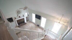 A spacious room with a fireplace, a ceiling fan, and large windows. - THE BIG HOUSE ~ With 620 sq ft EVENT SPACE ~ (view on YouTube "The Big House")
 (Nashville)
