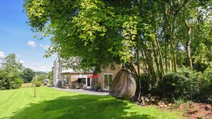 A house with a patio area, outdoor seating, and a hanging chair. - The Lodge at Harvest Farm (Ludlow)