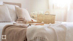 A neatly made bed with a woven basket and a book on it. - Villa PERLA by Abahana Villas (Teulada)