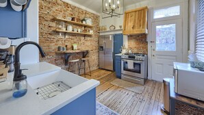 A kitchen with a brick wall, wooden cabinets, a stainless steel refrigerator, and a wooden countertop. - Cityside on North Prince, in Historic Downtown Lancaster (Lancaster)