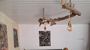 Een slaapkamer met een bed, een bank, een kroonluchter en kunstwerken aan de muur.