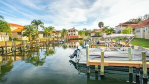 A marina with boats docked, surrounded by residential buildings and palm trees. - New, August 2024! Beautiful porch, view of Marina (Homosassa)