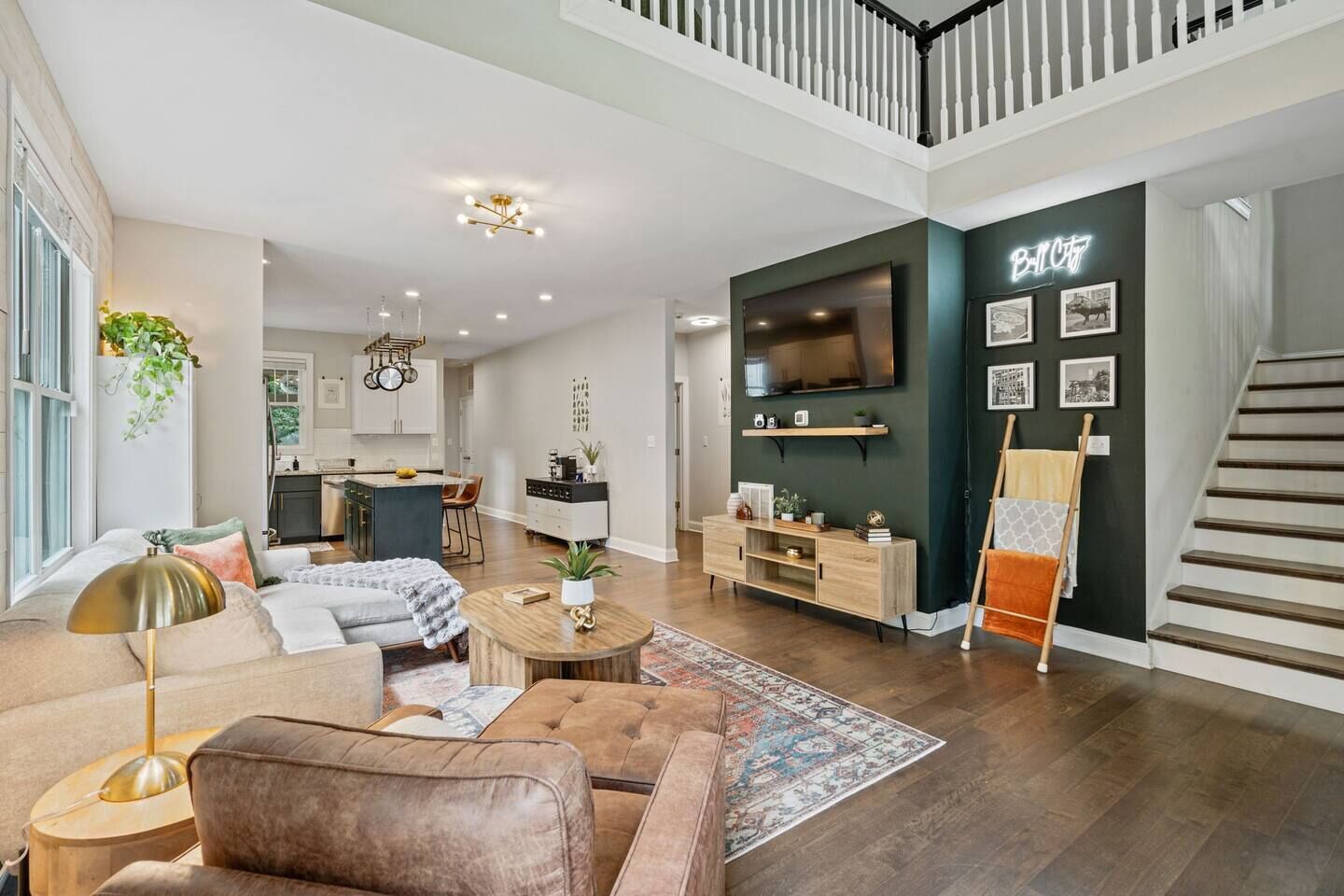 A spacious living room with a sofa, coffee table, and a TV mounted on the wall.