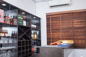 Uma área de bar com prateleiras repletas de garrafas e copos diversos.