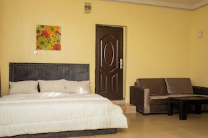 Quarto com uma cama grande, um sofá e uma porta.
