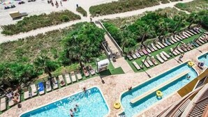 A pool area with multiple swimming pools, sun loungers, and umbrellas. - Oceans Crest! Oceanfront View Pools Putt Putt Spa (Myrtle Beach)