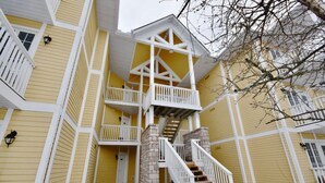 A multi-story yellow building with white railings and a central staircase. - Luxury Suite, Full Kitchen, Heated Pool (Shanty Bay)