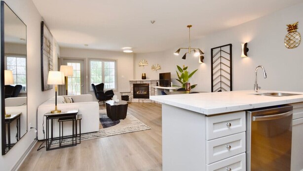 A modern kitchen with a central island, white cabinetry, and a built-in dishwasher. - Luxury Suite, Full Kitchen, Heated Pool (Shanty Bay)